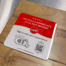 GIF showing a ReviewBoost Yelp review plaque on a table, demonstrating its shiny finish as light reflects off the surface